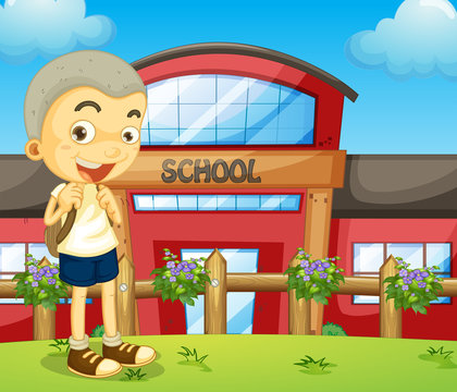 A boy standing near the school