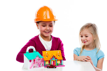 two cute little girls play with builders