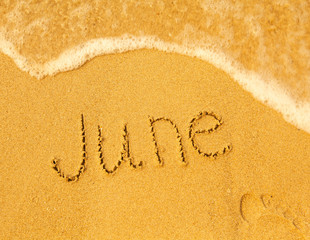 June - written in sand on beach texture