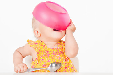 Little girl with a pink plate, on a gray background