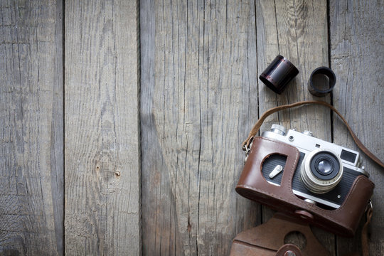 Old retro camera on vintage wooden boards abstract background