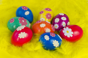 Bunte Ostereier mit Blumen und gelbe H&uuml;hnerfedern