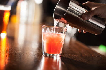 Barman serving a cocktail from a shaker