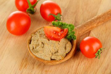 Fresh pate on wooden spoon, on wooden background
