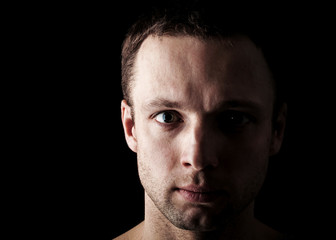 Obraz premium Young Caucasian man's closeup portrait on black background