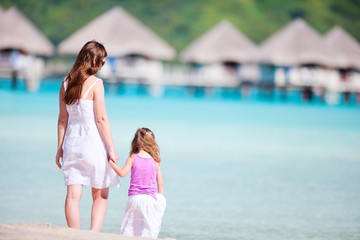 Fototapeta na wymiar Mother and daughter at resort beach
