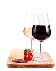 two wine glasses with red and white wine, tomato and cheese