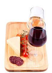 two wine glasses with red and white wine, tomato and cheese