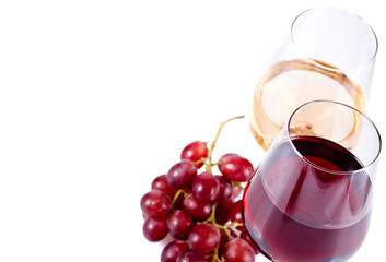 two wine glasses with red and white wine and grapes