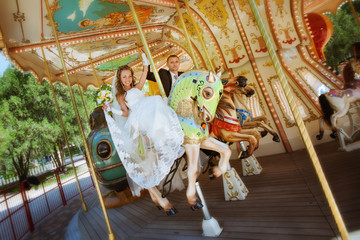 beautiful bride and groom riding a carousel