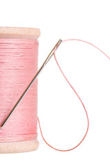 Spool of pink sewing thread with needle