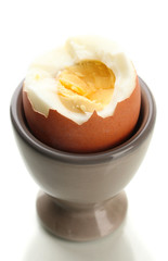 Boiled egg in egg cup, isolated on white