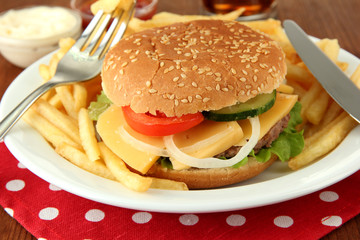 Tasty cheeseburger with fried potatoes, on bright background