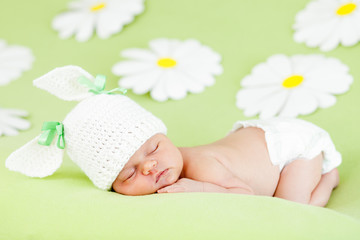 Obraz na płótnie Canvas newborn baby girl spania na zielonej łące wśród kwiatów