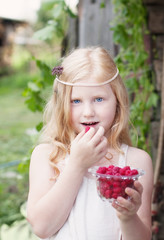 little girl holding raspberries