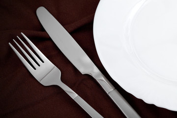 The knife and fork lie near a plate.