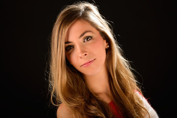 Fototapeta premium Young blonde woman studio portrait on black background