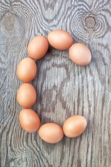 A letter c from the eggs for easter. On a wooden texture.