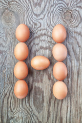 A letter h from the eggs for easter. On a wooden texture.