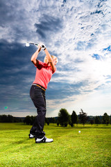 Young golf player on course doing golf swing