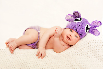 A newborn baby in purple knitted cap