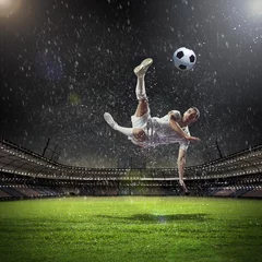 Selbstklebende Fototapeten Fußballspieler, der den Ball schlägt © Sergey Nivens