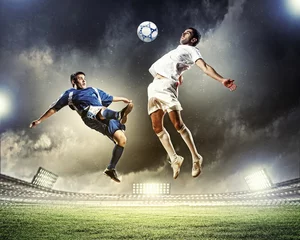 Fotobehang Voetbal twee voetballers die de bal slaan