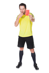 Soccer judge whistling and showing yellow card