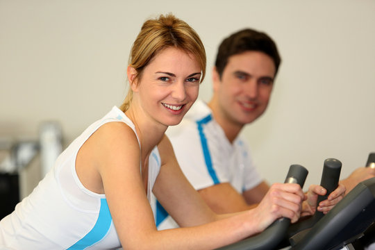 People exercising on bicycles in fitness gym