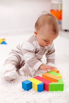 Baby girl playing eith wooden blocks