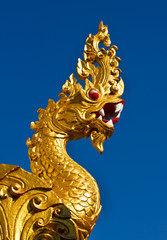 Fototapeta na wymiar Złoty posąg smoka samodzielnie na niebieskim tle