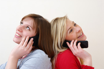 Dos mujeres conversando por teléfono celular.