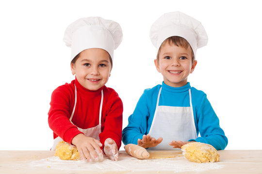 Two kids kneading the dough together