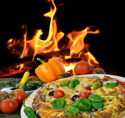 Pizza, gebacken in Holzkohleofen, vor offenem Feuer