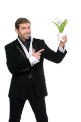 Smiling young businessman pointing his finger at the flower. Iso