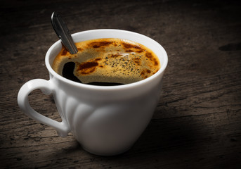 a cup of coffee on an old wooden table - vintade style