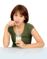 Isolated young asian woman with a glass of milk