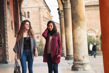 Two girls walking in Saint Stephen square, Bologna, Italy