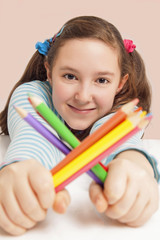 Smiling girl holding color pencils