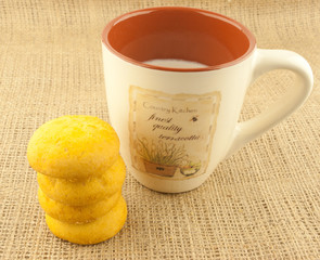 cup of milk and cookies on a background of burlap