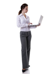 Businesswoman working at a laptop full length isolated on white