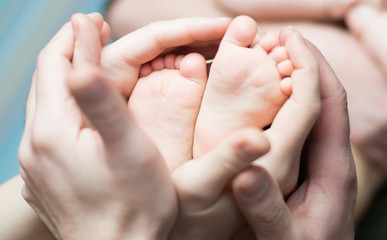 Obraz na płótnie Canvas Parents holding little newborns feets