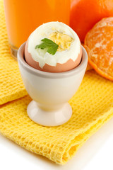 Light breakfast with boiled egg and glass of juice, close up