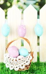 Art Easter background with eggs hanging on fence