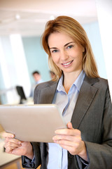 Businesswoman standing in office with tablet