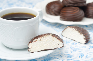 cup of black coffee and marshmallows in chocolate in a cut