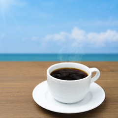 cup of coffee on a wooden table on a background of blue sky