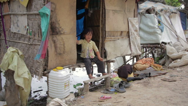 Cambodian boy in slum, shacks at background