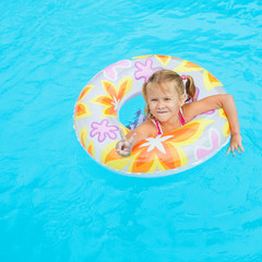 little girl in the pool  with rubber ring