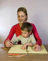 Happy woman helping kid write